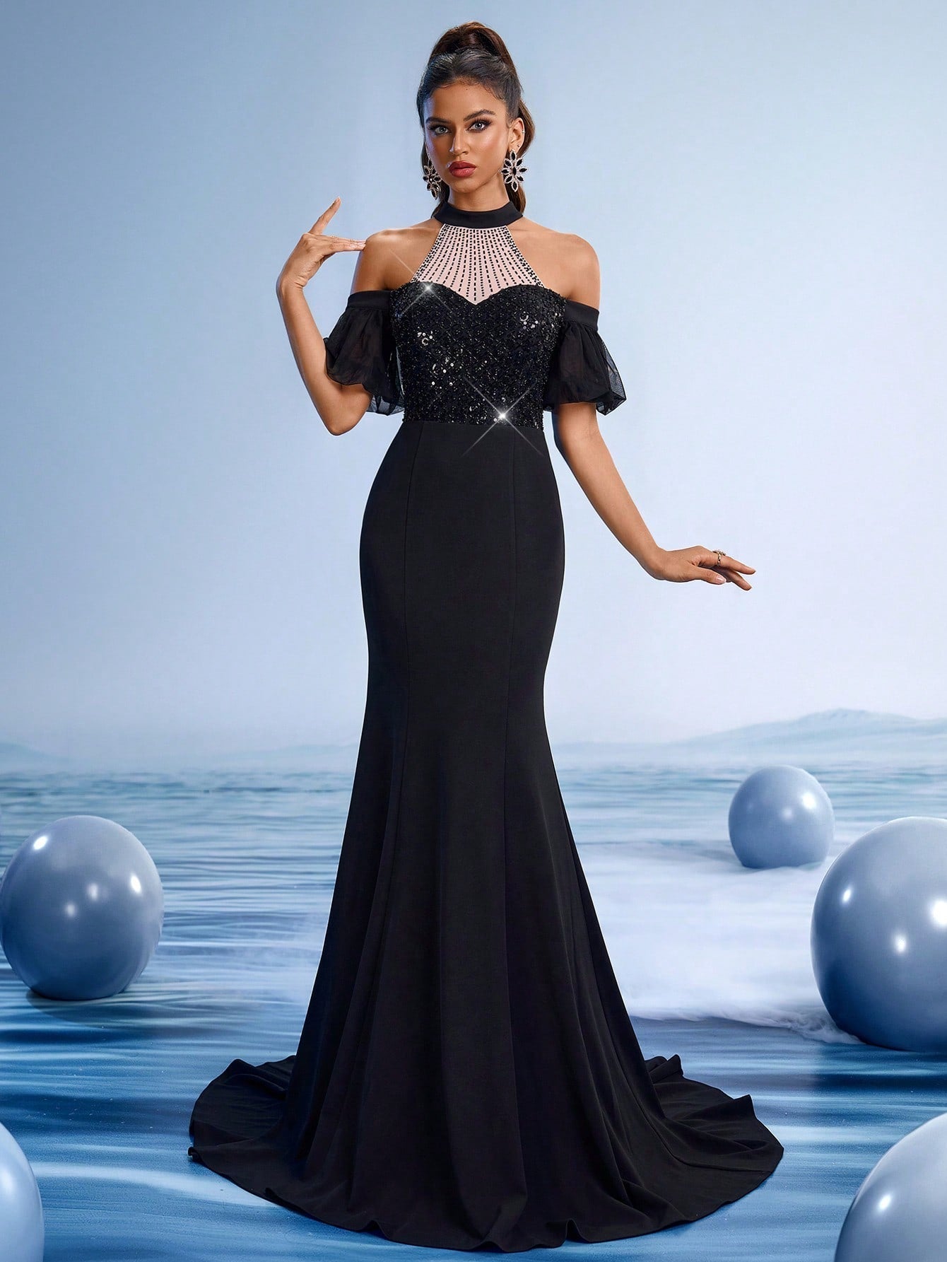 Elegant black beaded halter mermaid evening gown with sheer tulle sleeves and rhinestone bodice for formal gala or prom night.