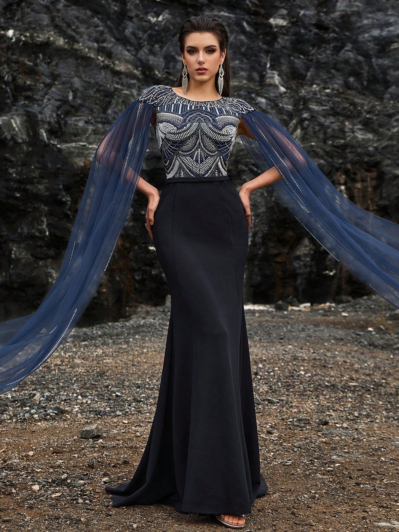 Glamorous navy blue mermaid evening gown featuring silver crystal-embroidered bodice, elegant sheer tulle cape sleeves, and a high slit for formal galas or red carpets.
