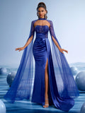 Royal blue embellished evening gown featuring a halter sheer cape, sparkling sequined bodice, elegant pleated satin waist, and a high slit for formal galas or red carpets.