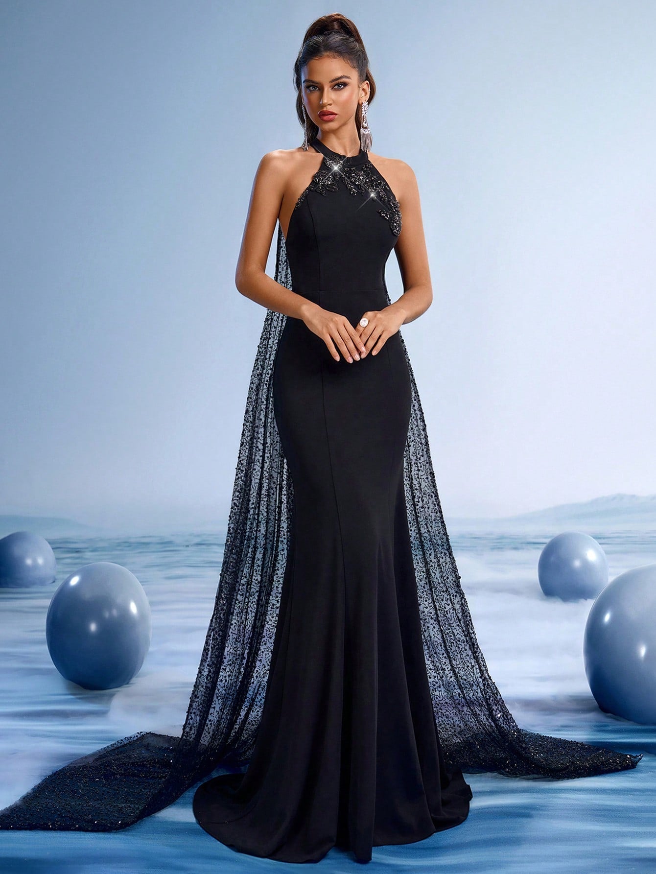 Elegant black halter mermaid evening gown with beaded neckline and a dramatic shimmering sequin sheer cape train for formal galas.