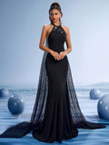 Elegant black halter mermaid evening gown with beaded neckline and a dramatic shimmering sequin sheer cape train for formal galas.