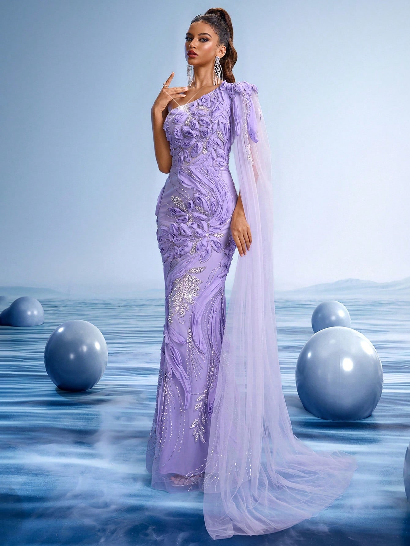 Elegant lavender one-shoulder mermaid evening gown with 3D floral crystal beading and a long sheer flowing cape train for gala or wedding guests.